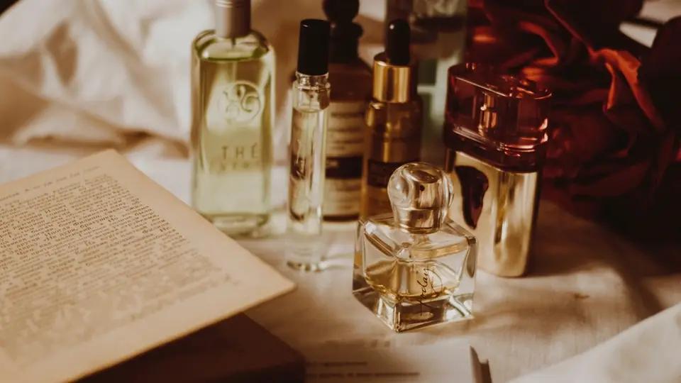 Parfumflaschen rund um ein aufgeschlagenes Buch